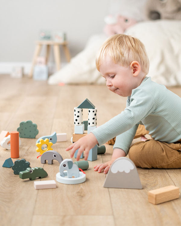 Boy playing with Done by Deer building block set