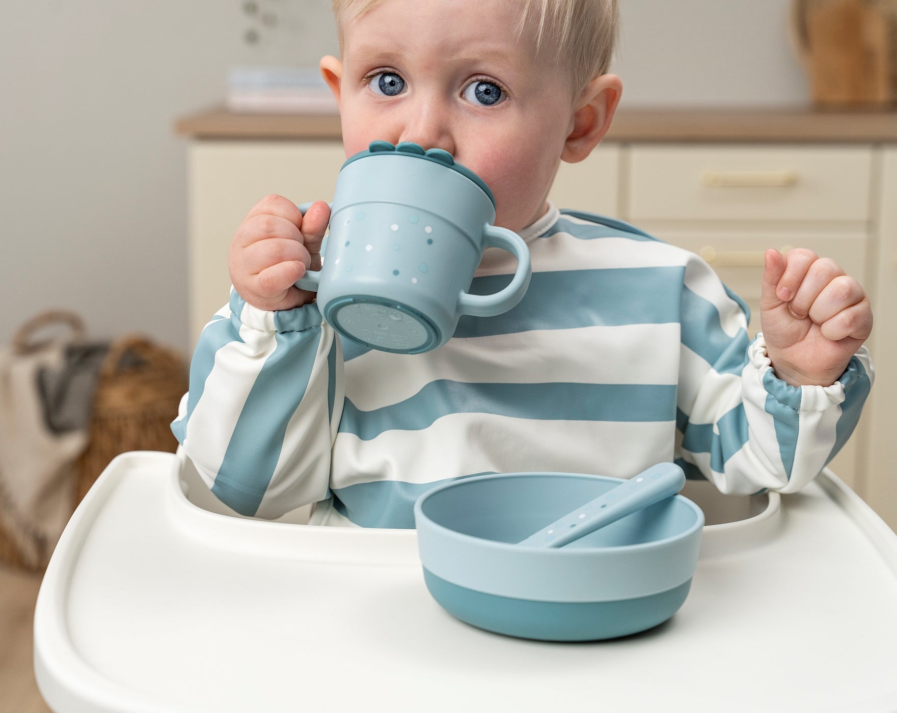 Boy drinking from a blue Done by Deer Foodie spout and a snack cup