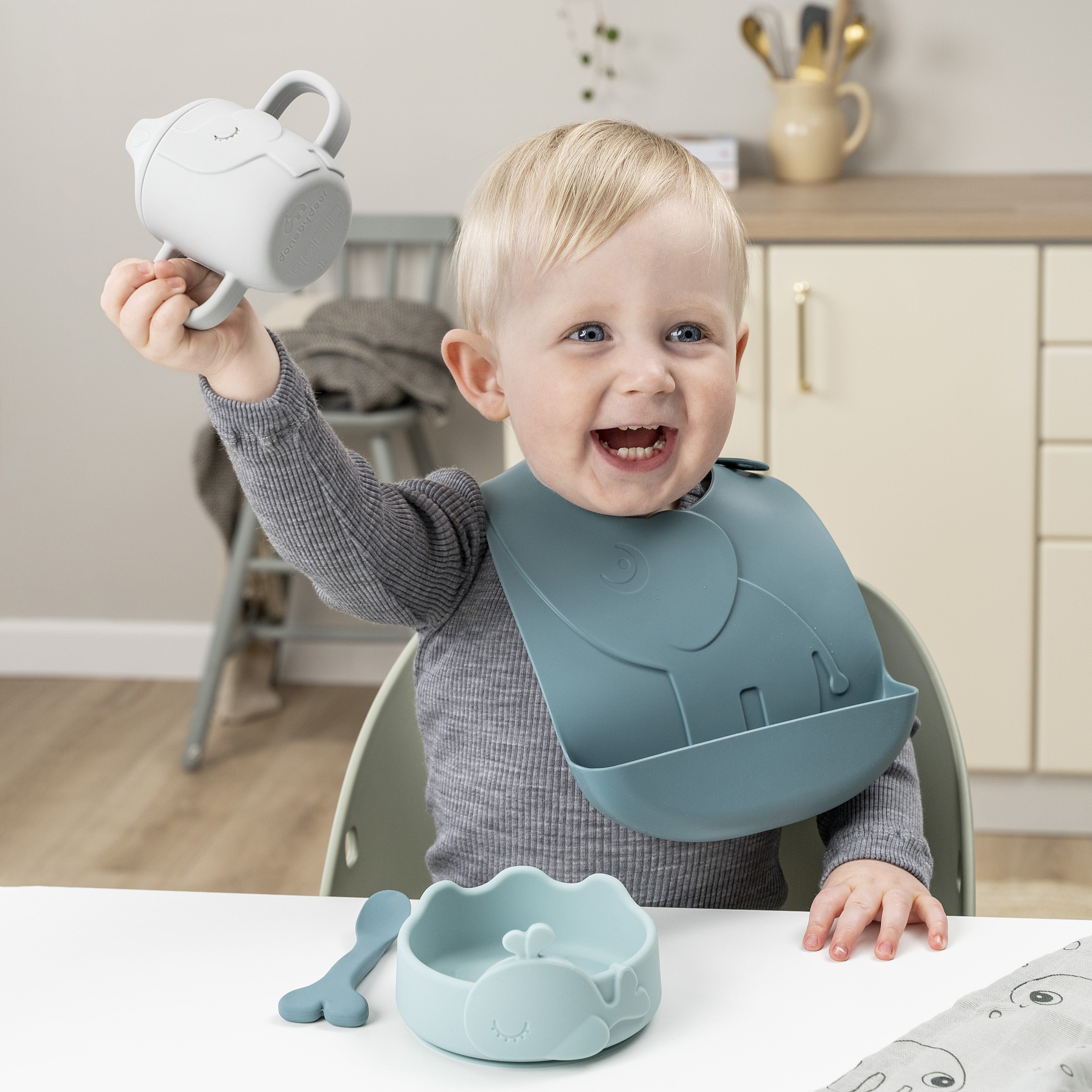 Boy at mealtime with Done by Deer baby suction bowl, spout cup and a silicone bi with Elphee the elephant