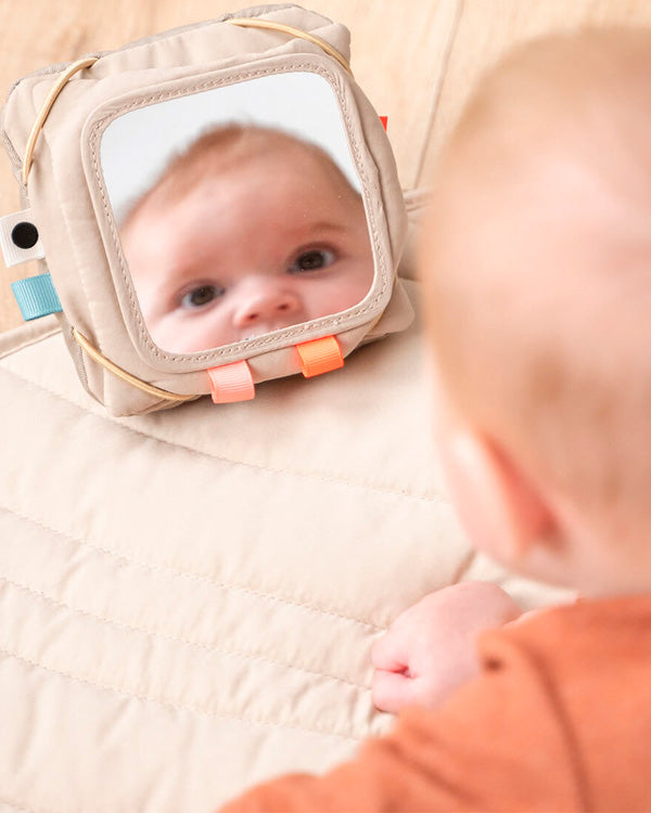 baby looking at themselves in a Done by Deer baby mirror