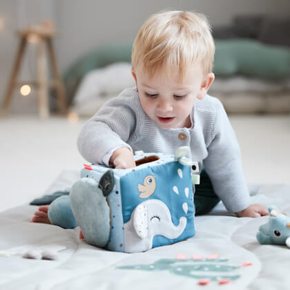 Kid plays with activity toy discovery cube from Done by Deer